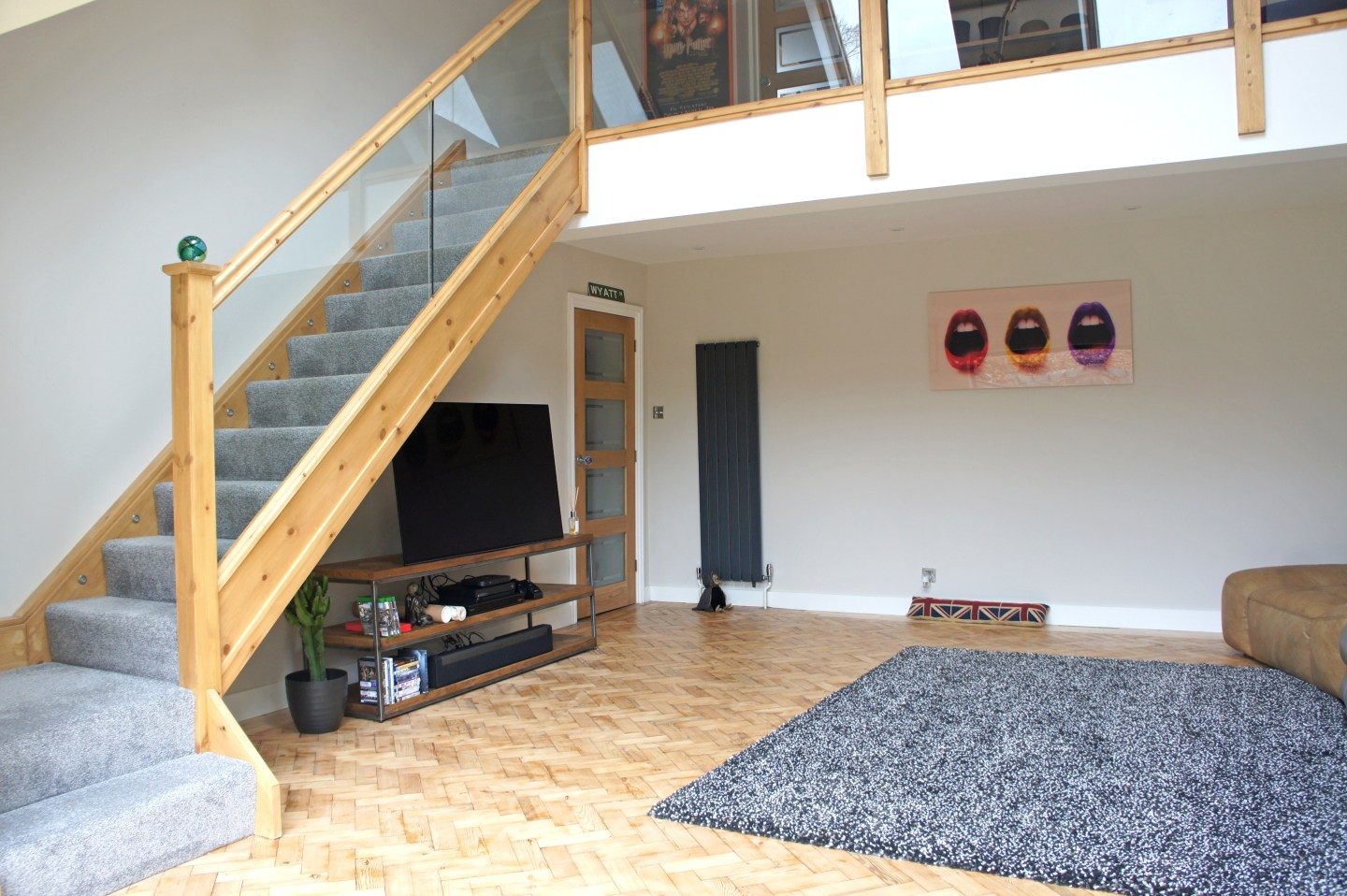 A living room area with a staircase and parquet flooring in a property extension